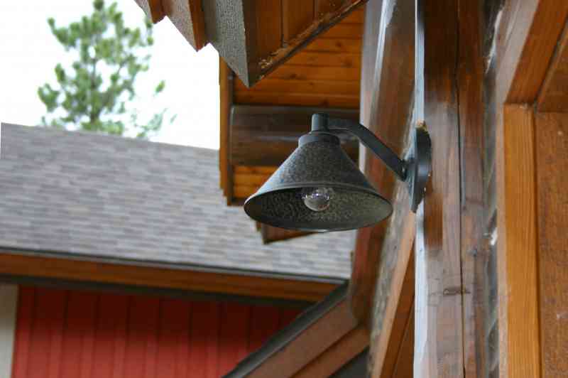 An exterior barn light cut to fit perfectly into the log siding.
