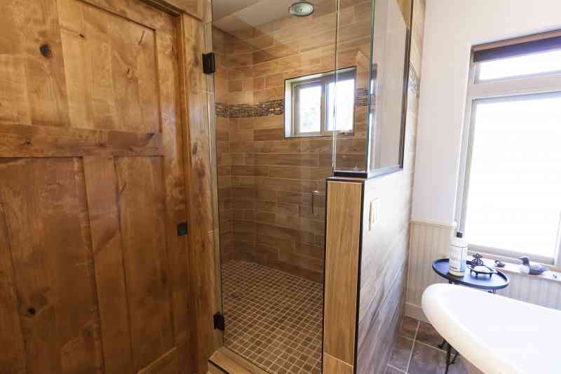 The master walk-in shower with a glass door and half glass wall.