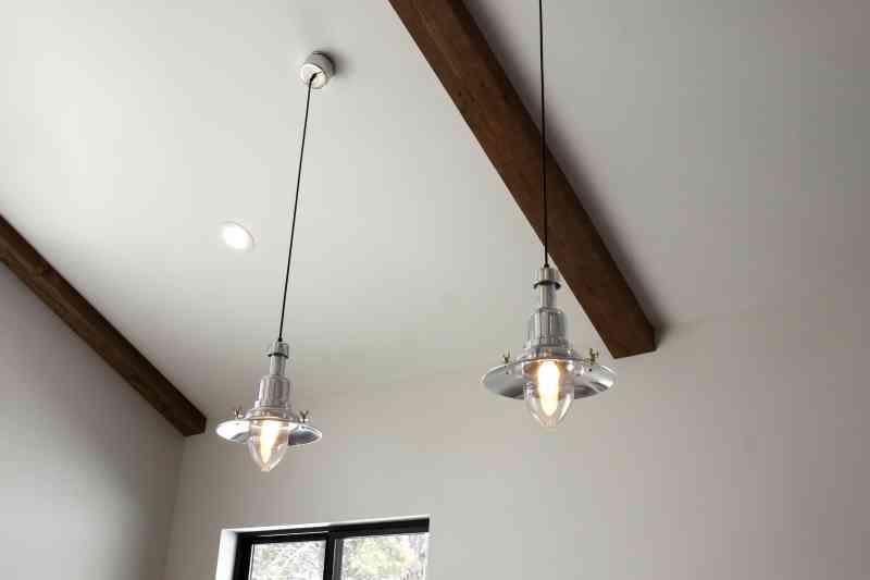 Farmhouse pendant lights hang over the dining table.