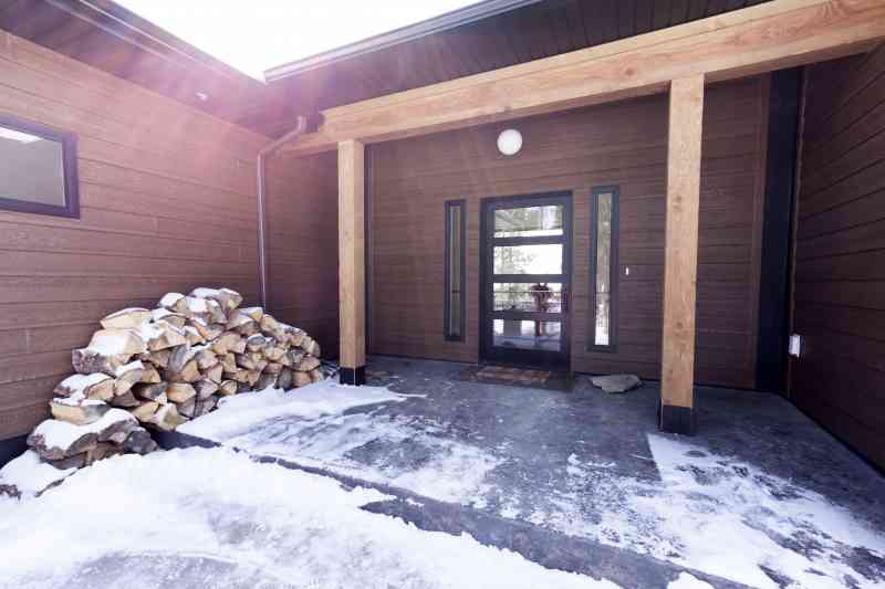 The home's entrance is framed by large timbers and a stamped concrete porch.